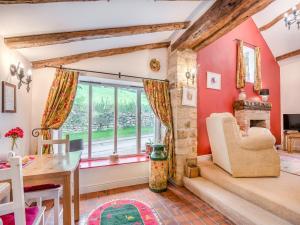 a living room with red walls and a fireplace at Bridge Cottage - W43184 in Hawnby