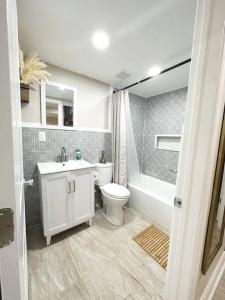 a bathroom with a toilet and a sink and a tub at Beautiful Golden Oasis in Philadelphia
