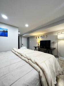 duże białe łóżko w pokoju z telewizorem w obiekcie Beautiful Golden Oasis w Filadelfii