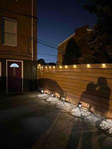 Ein Schatten eines Paares auf einem Zaun mit Lichtern in der Unterkunft Beautiful Golden Oasis in Philadelphia