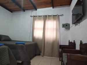 een slaapkamer met een bed en een raam met gordijnen bij Casa Cristal in Antigua Guatemala