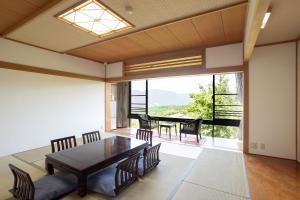 een eetkamer met een tafel en stoelen en een groot raam bij Hakone Ashinoko Bikeikan 箱根芦ノ湖 美景館 in Hakone