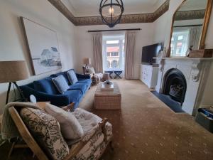 a living room with a blue couch and a fireplace at QPO QUEENSCLIFF in Queenscliff