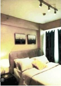 a bedroom with a bed and a couch and two windows at The Lancris Residences, 2 Bedrooms, 1 Bathroom, Livingroom & Kitchen Pool is free! in Manila