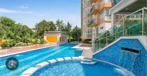 a swimming pool in front of a building at The Lancris Residences, 2 Bedrooms, 1 Bathroom, Livingroom & Kitchen Pool is free! in Manila