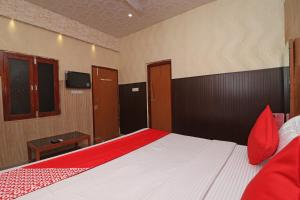 OYO 13234 Hotel Mahak في Bijnaur: غرفة نوم مع سرير وتلفزيون على الحائط