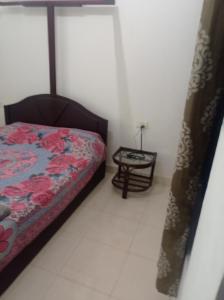 1 dormitorio con 1 cama y mesa auxiliar en Heaven Goa Guesthouse, en Benaulim