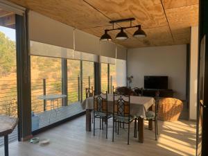 a dining room with a table and chairs and a balcony at Casa Familiar Lago Rapel in Las Balsas