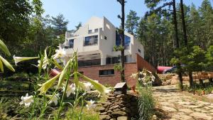 a house in the middle of a garden with flowers at Forestel Meomul in Suncheon
