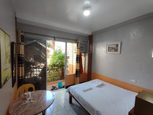 Habitación con cama, mesa y ventana en Mango House Apartments, en Panglao