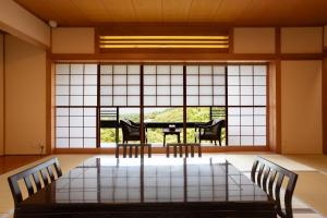 a room with a table and chairs and a large window at Hakone Ashinoko Bikeikan 箱根芦ノ湖 美景館 in Hakone