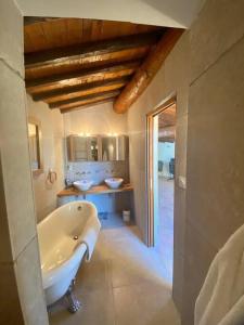 y baño grande con 2 lavabos y bañera. en Les Calades, en Lédenon