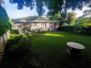 a yard with a bench and a house at HeCo House in Monteverde Costa Rica