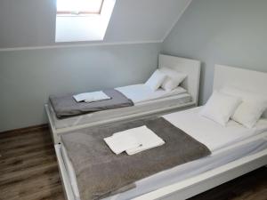 2 Betten in einem kleinen Zimmer mit Fenster in der Unterkunft Apartment with a swimming pool in Stepniczka in Stepnica