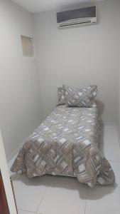 a bed in a white room with a comforter and pillows at Rsolmar2023 in Tamandaré +9 photos