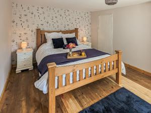 a bedroom with a bed with a tray with flowers on it at Pixies Wood Cottage in Ludham