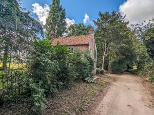 an old brick house on a dirt road at Pixies Wood Cottage in Ludham