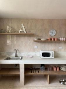 a kitchen with a sink and a microwave on a counter at Casa Verbena in Cisneros