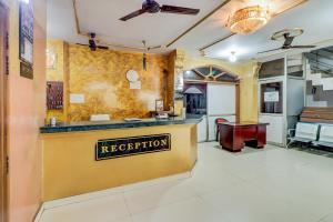 a kitchen with a yellow counter with a sign that reads reception at J C Guest House in Hasanganj