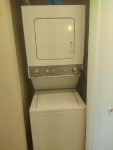 a white washer and dryer with a mirror on top of it at 1 bedroom condo F1 / Superbowl Availability in Las Vegas