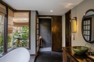 La salle de bains est pourvue d'une baignoire, d'un lavabo et d'un miroir. dans l'établissement Avana Retreat, à Mai Châu