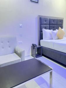 a hotel room with a bed and a couch at Rigg Hotel in Apapa Eleko