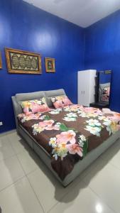 Un dormitorio con una cama con flores. en Nurkasih Homestay Jerantut, en Jerantut