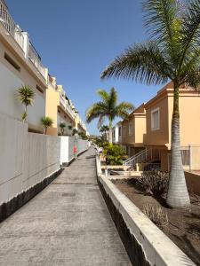 a sidewalk with palm trees next to some buildings at One bedroom apartment ZEN with great view, pool, WiFi in Chayofa