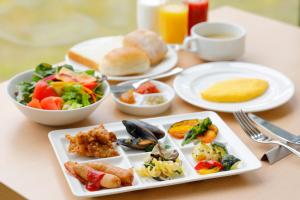 una mesa con platos de comida y una taza de café en Kanazawa Sainoniwa Hotel en Kanazawa