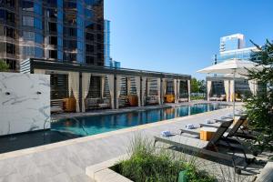 a swimming pool with lounge chairs and a building at JW Marriott Dallas Arts District in Dallas