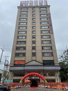 SENNA SUNSHINE INTERNATIONAL HOTEL في سيهانوكفيل: مبنى كبير أمامه موكب
