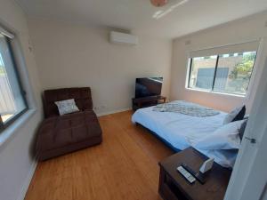 a bedroom with a bed and a couch and a chair at Town, Train, Pubs & River all close by in Echuca