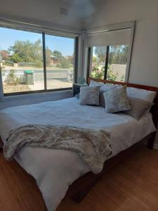 a bedroom with a large bed with a large window at Town, Train, Pubs & River all close by in Echuca
