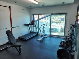 einen Fitnessraum mit mehreren Trainingsgeräten und einem großen Fenster in der Unterkunft Tory Hotel in Wellington