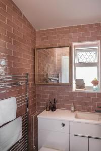 y baño con lavabo y espejo. en Picton House: Charming 3 bed property in quiet location en Ramsgate