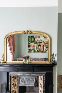 a mirror on top of a fireplace in a room at Picton House: Charming 3 bed property in quiet location in Ramsgate