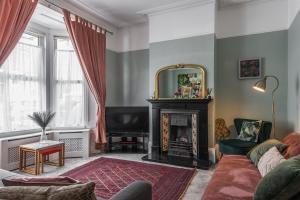 a living room with a fireplace and a mirror at Picton House: Charming 3 bed property in quiet location in Ramsgate