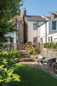 a garden with a wooden fence and a house at Picton House: Charming 3 bed property in quiet location in Ramsgate