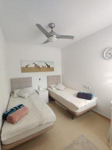 2 camas en una habitación con ventilador de techo en Casa Ana, en Murcia