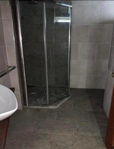 W łazience znajduje się prysznic ze szklanymi drzwiami. w obiekcie NR appartments w mieście Curepipe