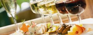 a plate of food and wine glasses on a table at Tranquil Retreat Spacious 2-Bedroom on a Serene Acreage in Kelowna