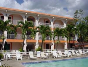 un hôtel avec des chaises et une piscine en face dans l'établissement Hotel Perichi's, à Cabo Rojo