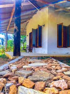 Um edifício com um monte de pedras à frente. em Nelumgala Cottage -Village Experience em Galewela