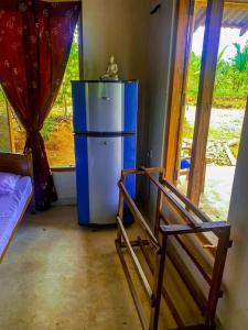 um pequeno frigorífico azul num quarto com uma janela em Nelumgala Cottage -Village Experience em Galewela