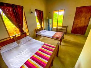 um quarto com 2 camas e uma janela em Nelumgala Cottage -Village Experience em Galewela