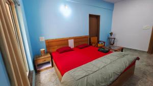 a bedroom with a red bed and a blue wall at AYM Yoga Resort Arambol GOA in Arambol