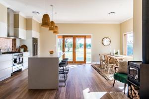 a kitchen and dining room with a table and chairs at Highgrove Cottage in Eurunderee