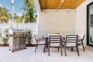 a patio with a table and chairs and a grill at Luxury Paradise walk to Las Olas -5 mins to Beach in Fort Lauderdale