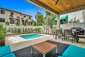 a patio with a table and chairs and a pool at Luxury Paradise walk to Las Olas -5 mins to Beach in Fort Lauderdale
