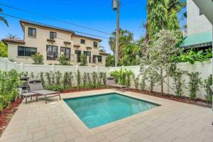 a swimming pool in front of a white fence at Luxury Paradise walk to Las Olas -5 mins to Beach in Fort Lauderdale